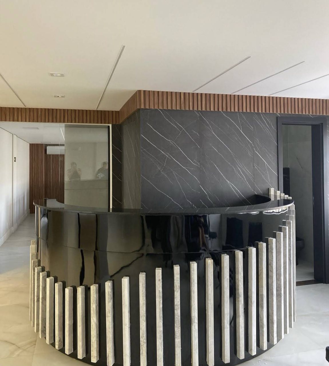 Balcão de recepção curvo em mármore preto veado